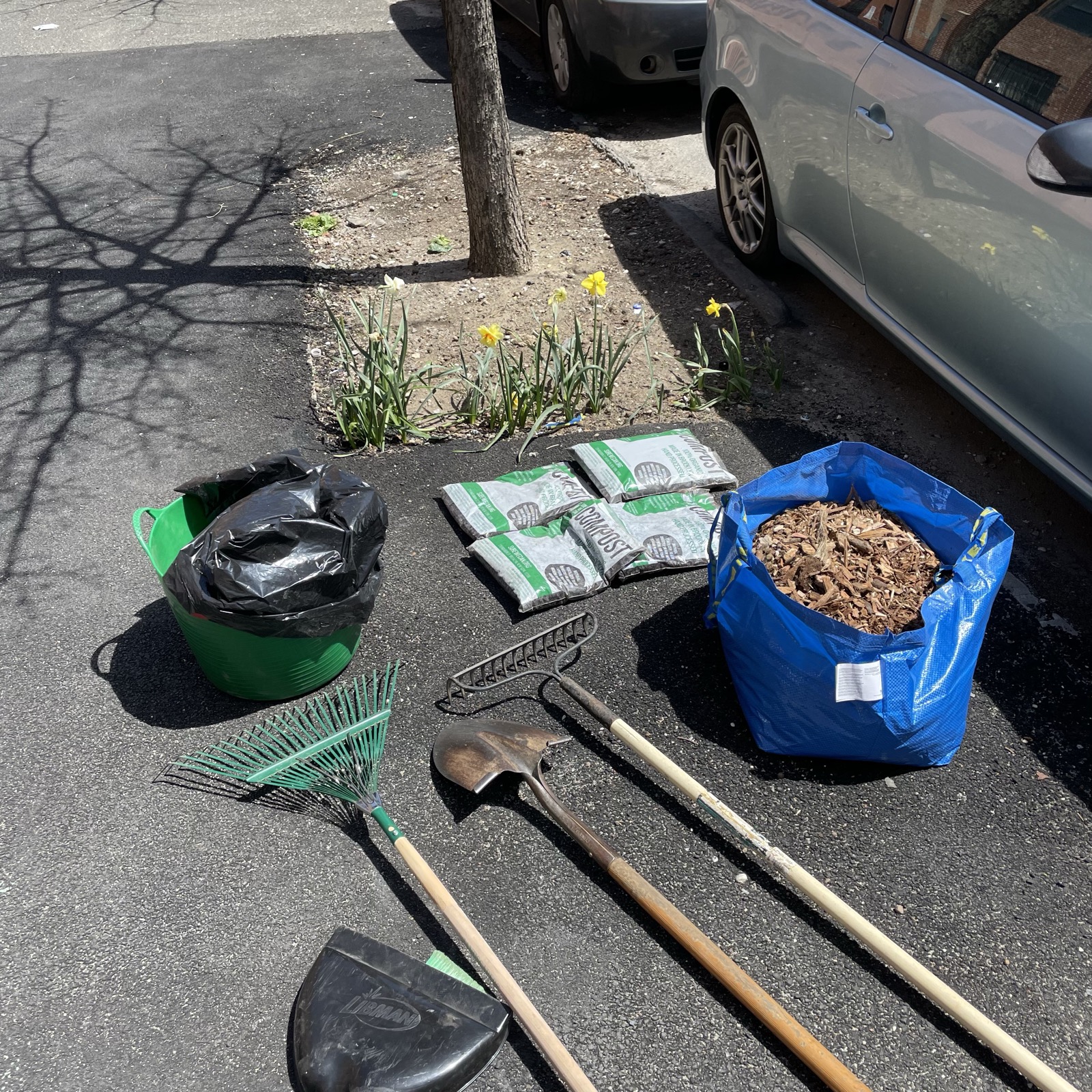 Cleanup tools and supplies laid out outdoors during an Earth Day event with water nearby