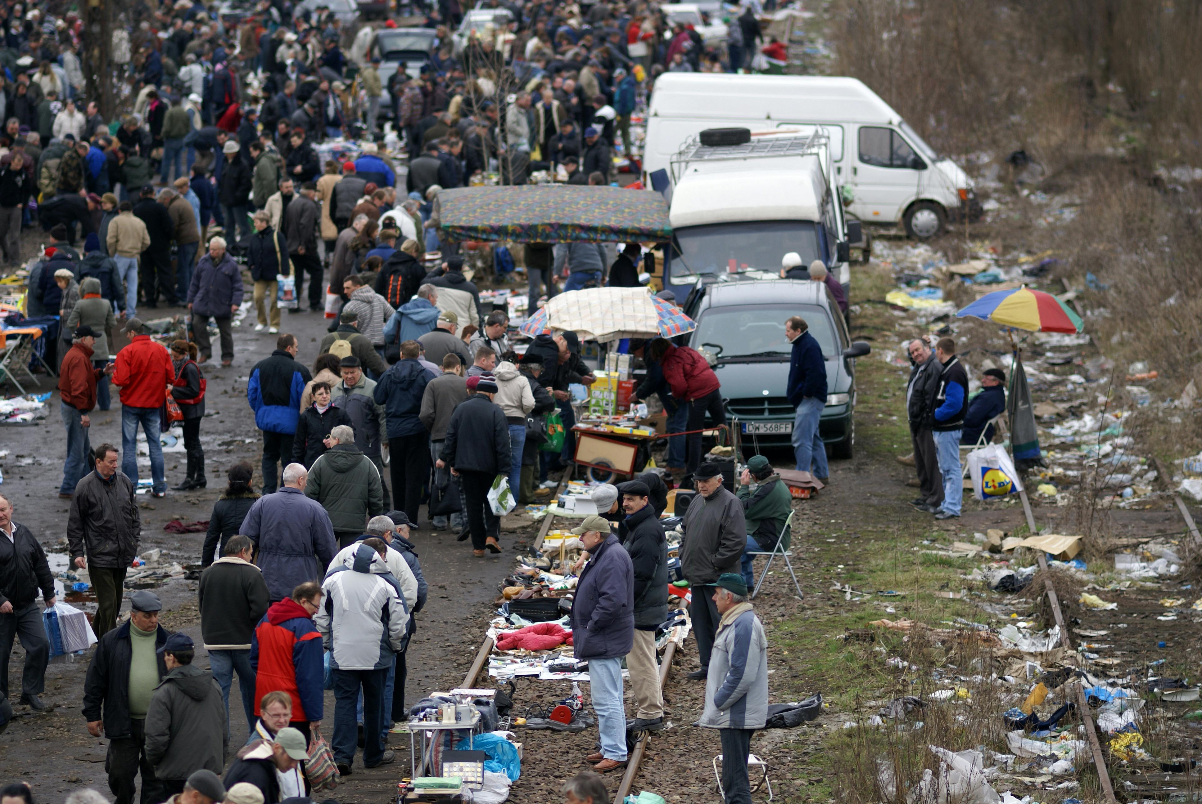 Busy outdoor flea market with long rows of shoppers and vendors during a full morning of browsing