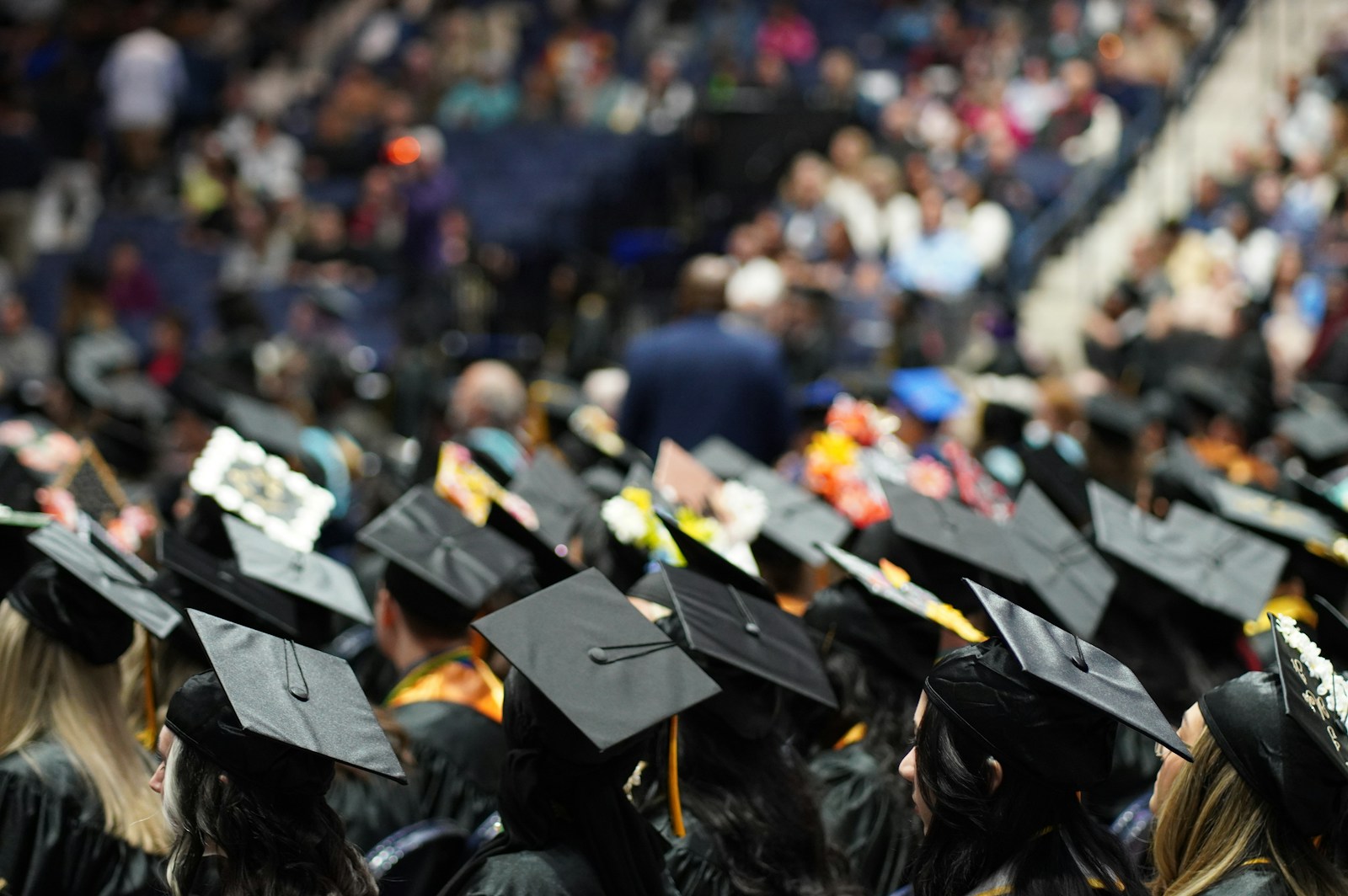 College graduates celebrating outdoors in caps and gowns during a sunny graduation weekend