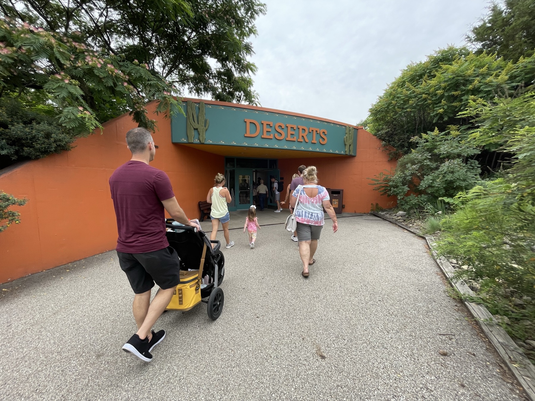 Visitors walking toward the Deserts entrance at the Indianapolis Zoo on a sunny day